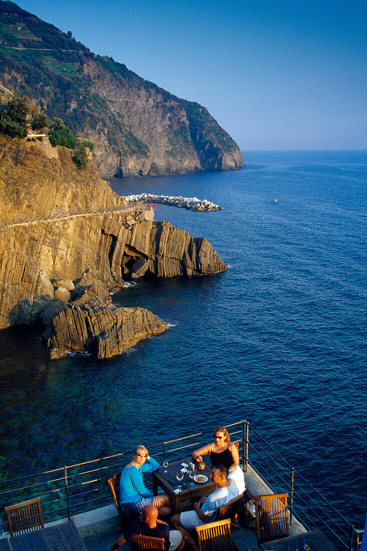 Menschen auf einer Restaurantterrasse am Meer, Cinque Terre, Ligurien, Italienische Riviera, Italien, Europa