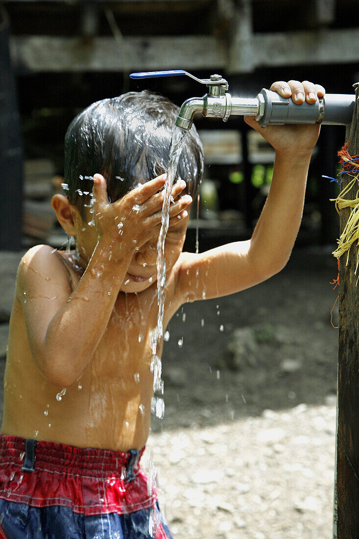INDONESIA  Boy taking a bath at a CRS provided tap in Paloh village, Pulo Aceh, Aceh  2 years after the Tsunami