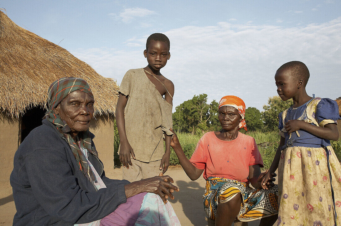 SOUTH SUDAN  Early morning scene on a farm homestead of Yei  Three generations sitting in front of their hut
