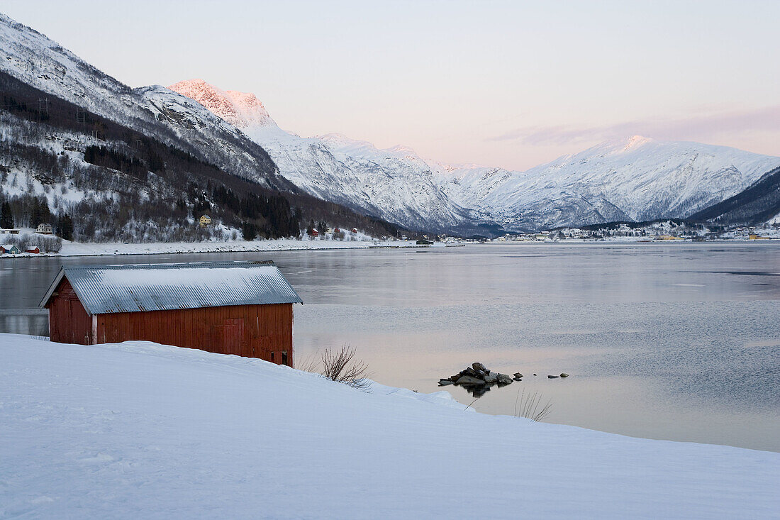 Hut in snow by fijord, Ofotfjorden near Bogen, near Narvik, Norway