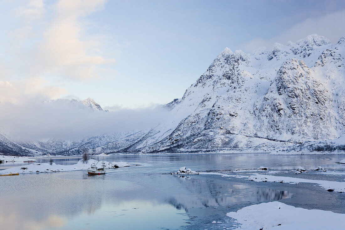 Fishing boat in bay in winter, Austvagoya Island, Lofoten Islands, Norway