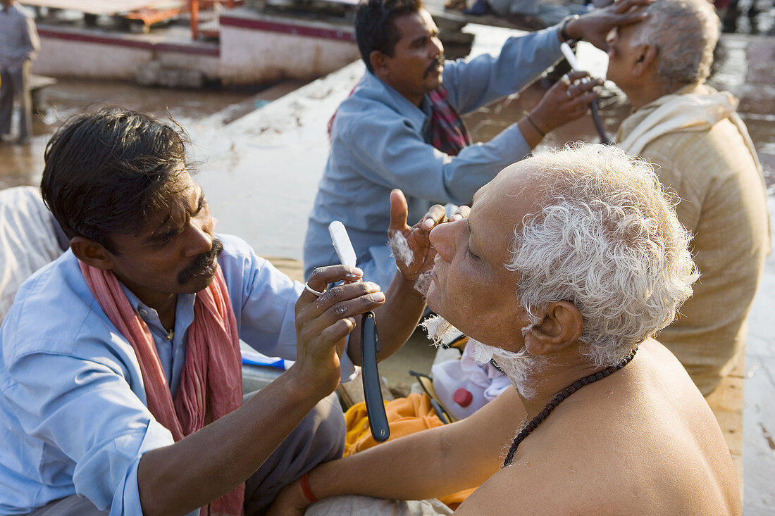 Men being shaved at Kumbh Mela festival. Allahabad, Uttar Pradesh, India