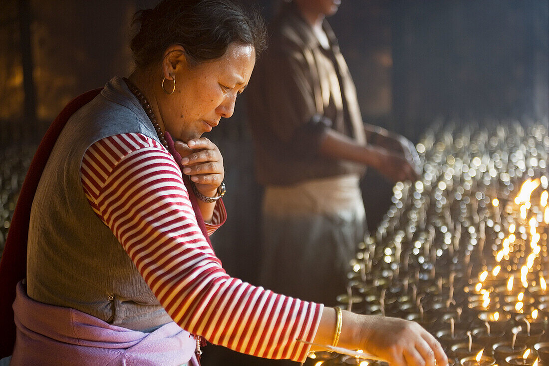 Lighting butter lamps, Bodhgaya. Gaya district, Bihar, India