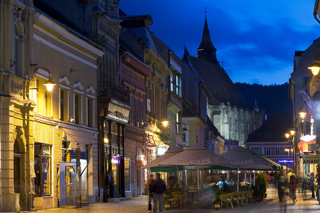 Outdoor restaurants/cafés with Lutheran Black Church in background, Brasov, Translyvania, Romania