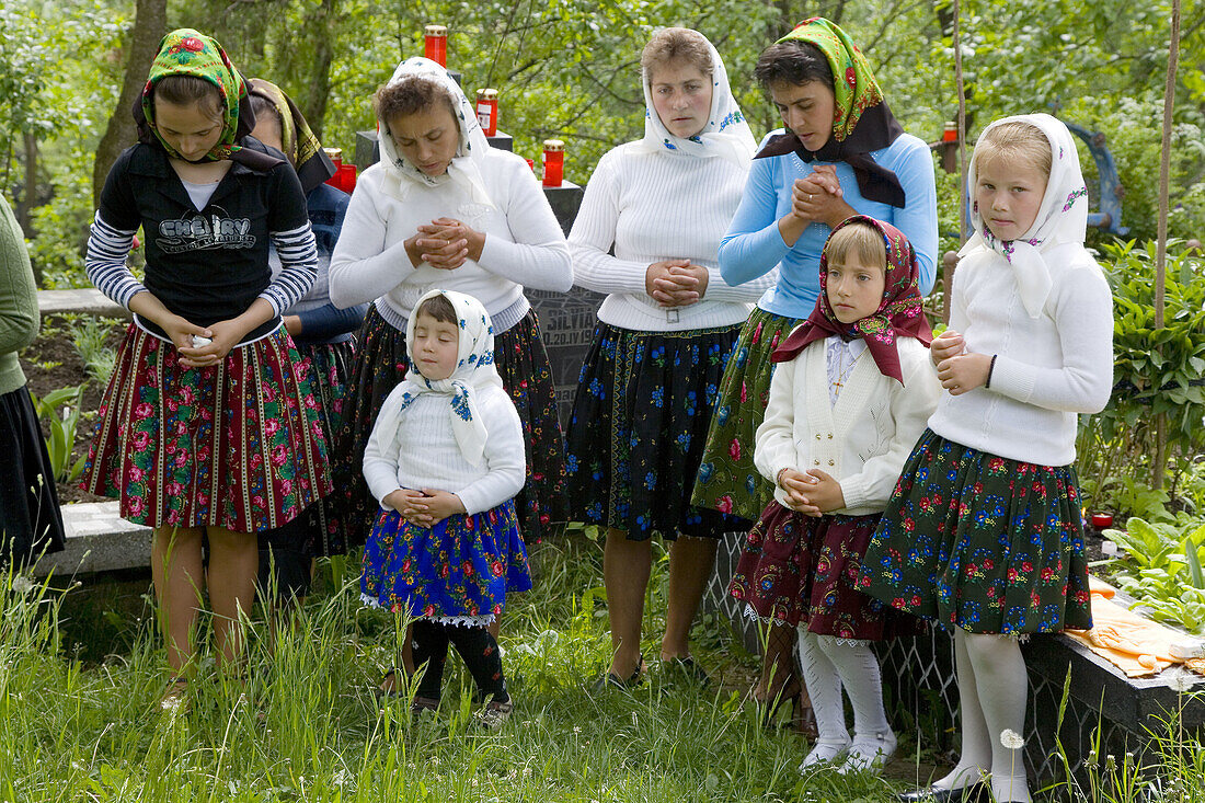 Church service women outside full wooden church listening to service, Budesti, Maramures, Romania