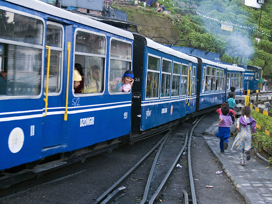 kids chasing the toy train as it leaves the station in Darjeeling