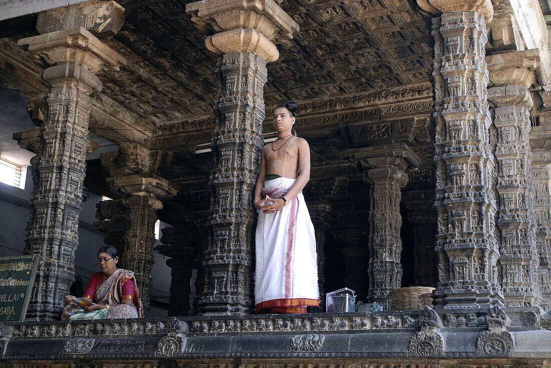 Temple priest at the Nritta Sabha or Hall of Dance with some fine pillars, Nataraja temple in Chidambaram, Tamil Nadu, India.