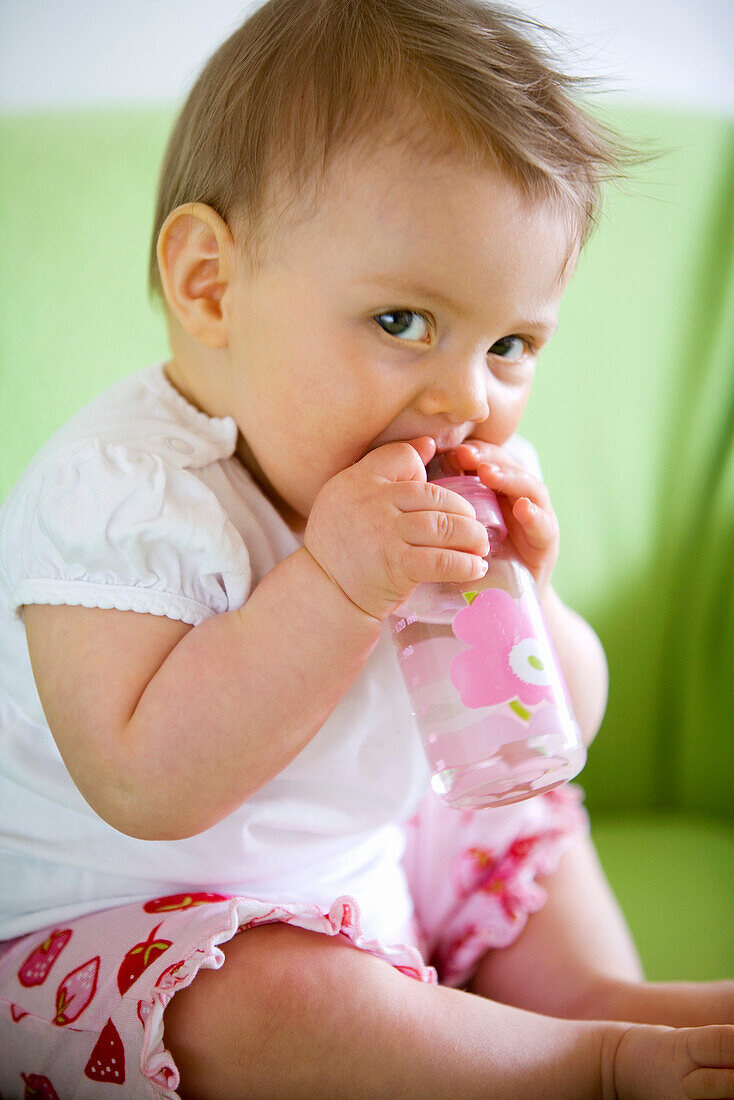 Baby girl (8 month) with a bottle, Vienna, Austria