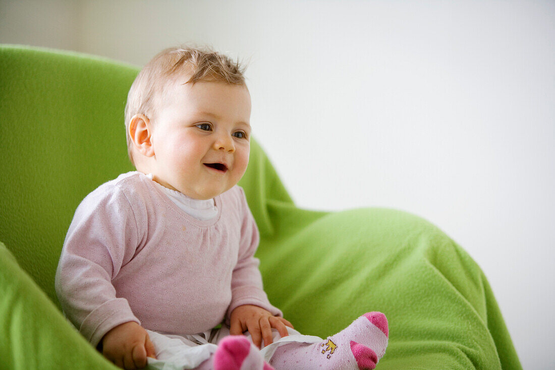 Baby girl (8 month) sitting in an armchair, Vienna, Austria