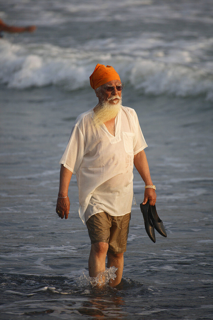 Man walking on Lighthouse beach, Kerala, India