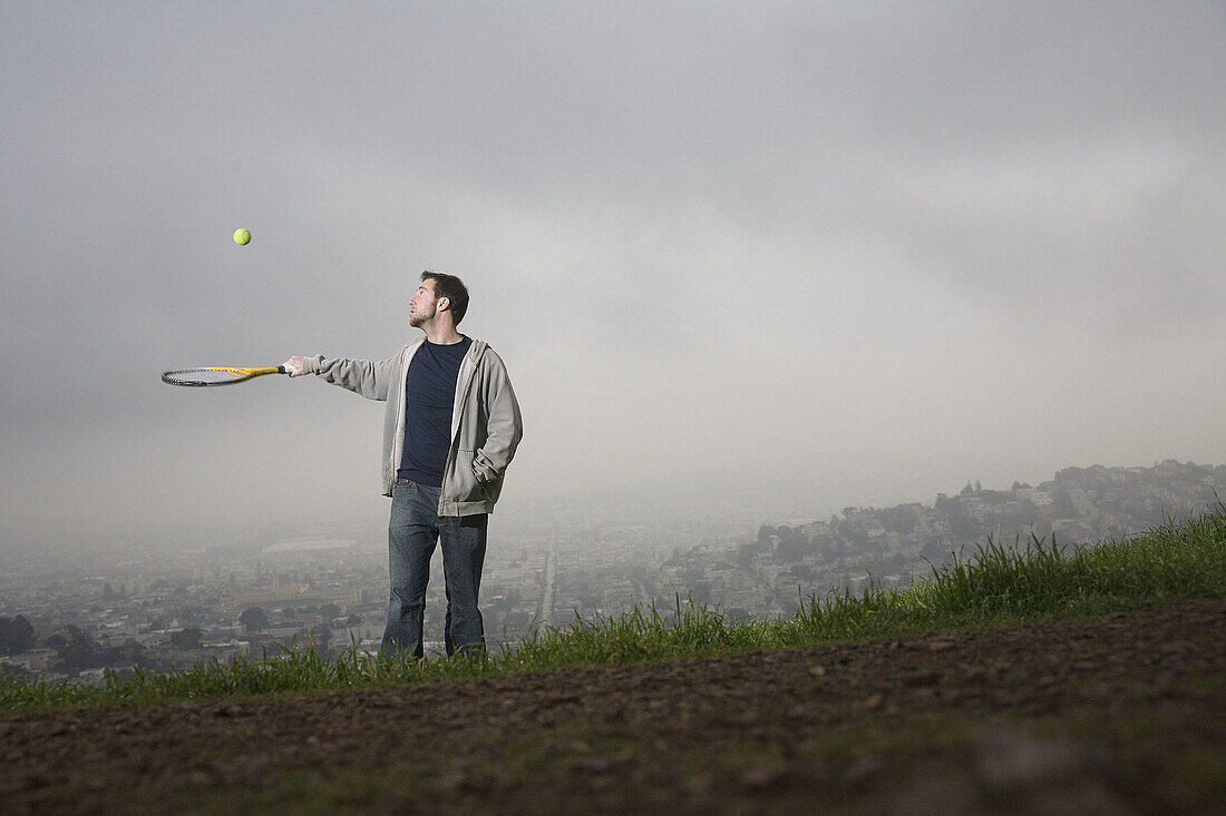 Young man with tennis racket, San Francisco, California, USA