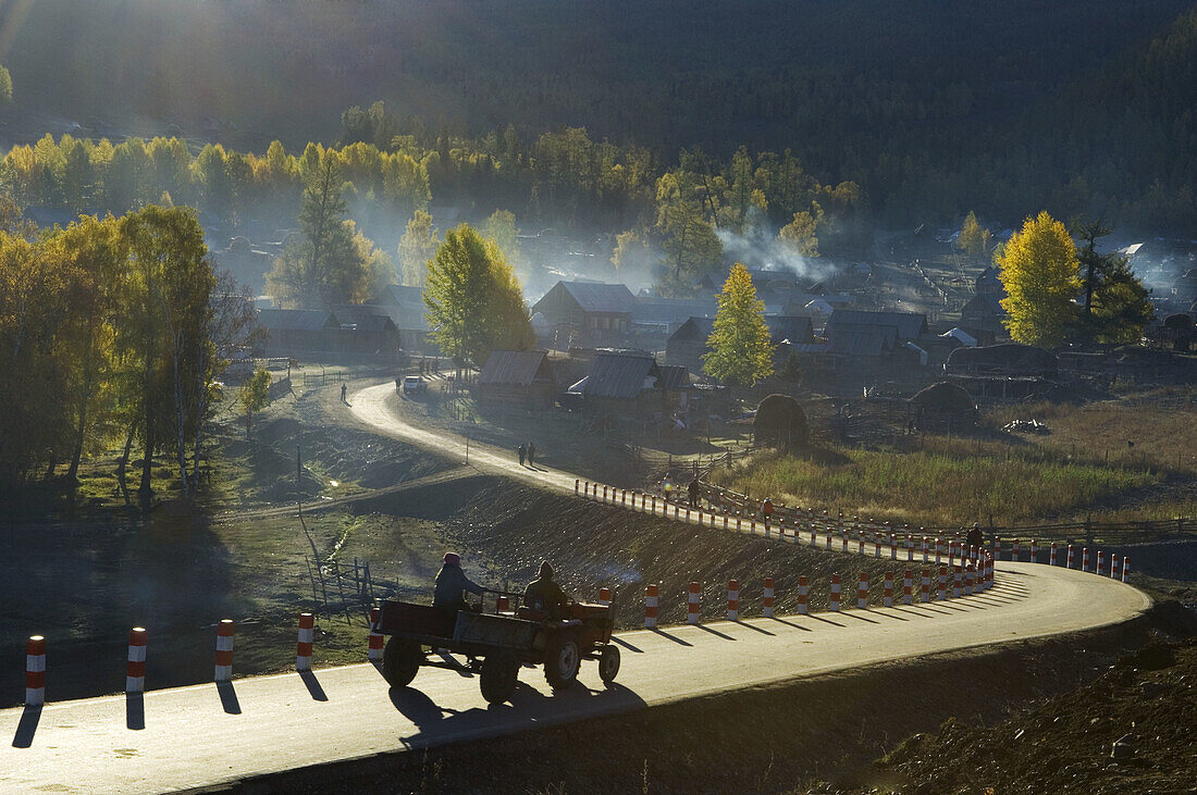 Two farmers riding on their tractor into the village at the early hours in Northwest Xinjiang, China