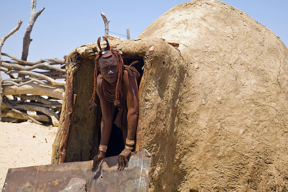 Himba woman looking out of her hut, Namibia
