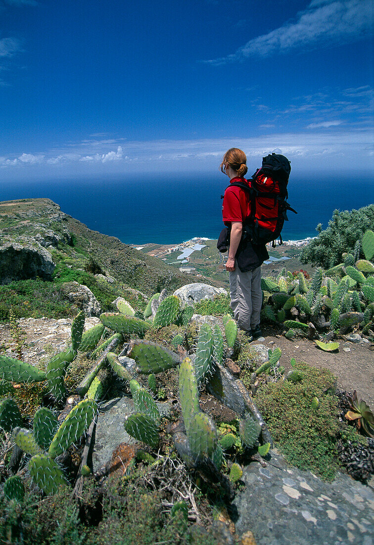Frau mit Rucksack an der Nordküste schaut aufs Meer, Teneriffa, Spanien, Europa