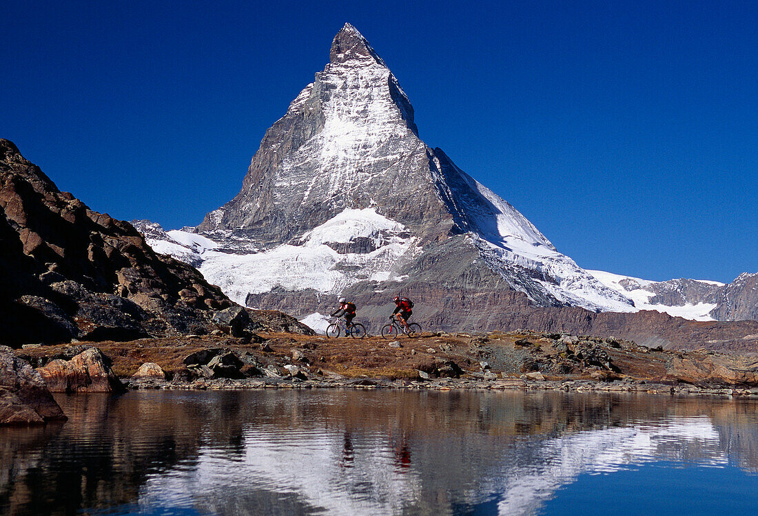 Mountain bikers at a lake in front of the Matterhorn mountain, Switzerland, Europe