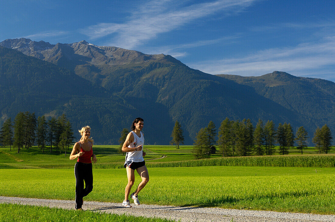 Ein Paar läuft in idyllischer Landschaft, Tirol, Österreich, Europa
