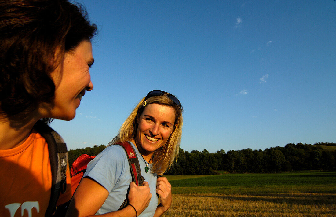 Zwei Frauen wandern im Sonnenlicht, Fränkische Schweiz, Bayern, Deutschland, Europa