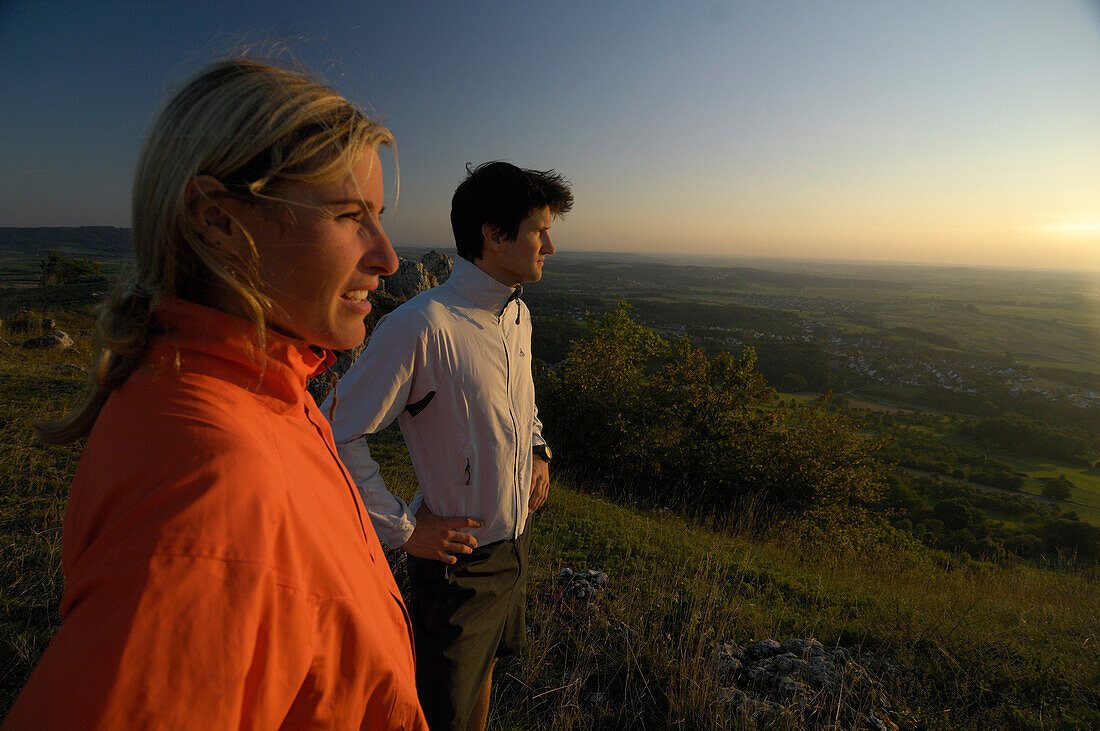 Joggers looking at the view at dusk, Franconian Switzerland, Bavaria, Germany, Europe