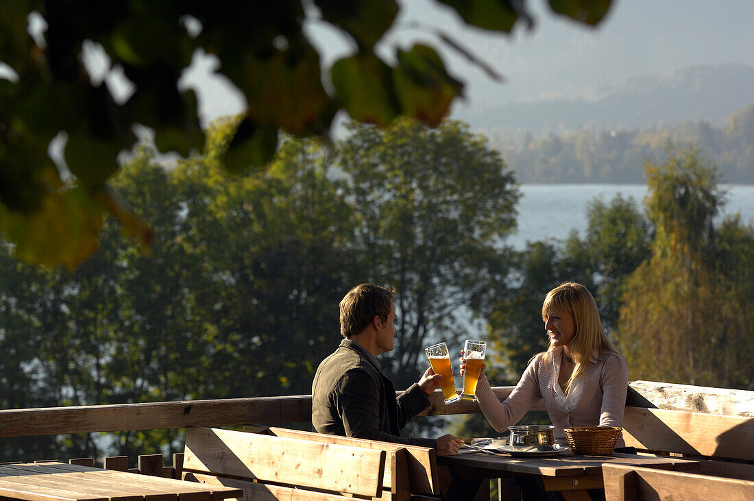 Young couple at a beer garden in the sunlight, lake Tegernsee, Bavaria, Germany, Europe