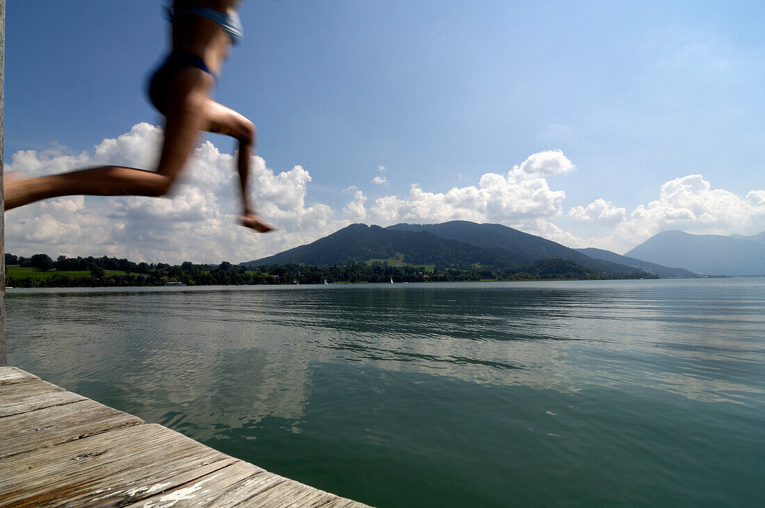Young woman jumping into a lake, near Gmund, Lake Tegernsee, Upper Bavaria, Bavaria, Germany