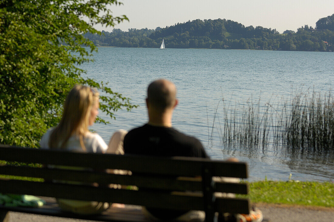 Couple having a rest on a bench near Lake Tegernsee, Upper Bavaria, Bavaria, Germany