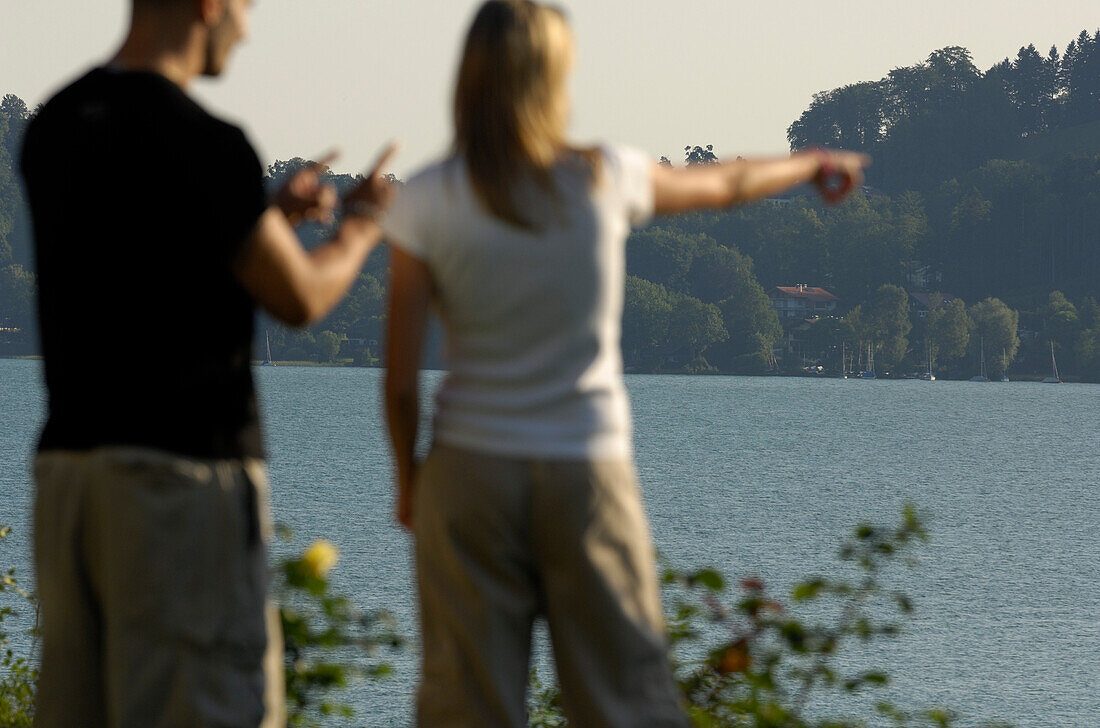 Couple at Lake Tegernsee, Woman is pointing her finger towards something, Lake Tegernsee, Upper Bavaria, Bavaria, Germany