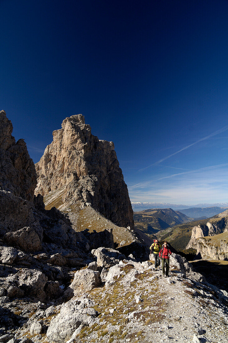 Two people hiking on gardena pass, near Wolkenstein, Dolomiten, South Tyrol, Italy