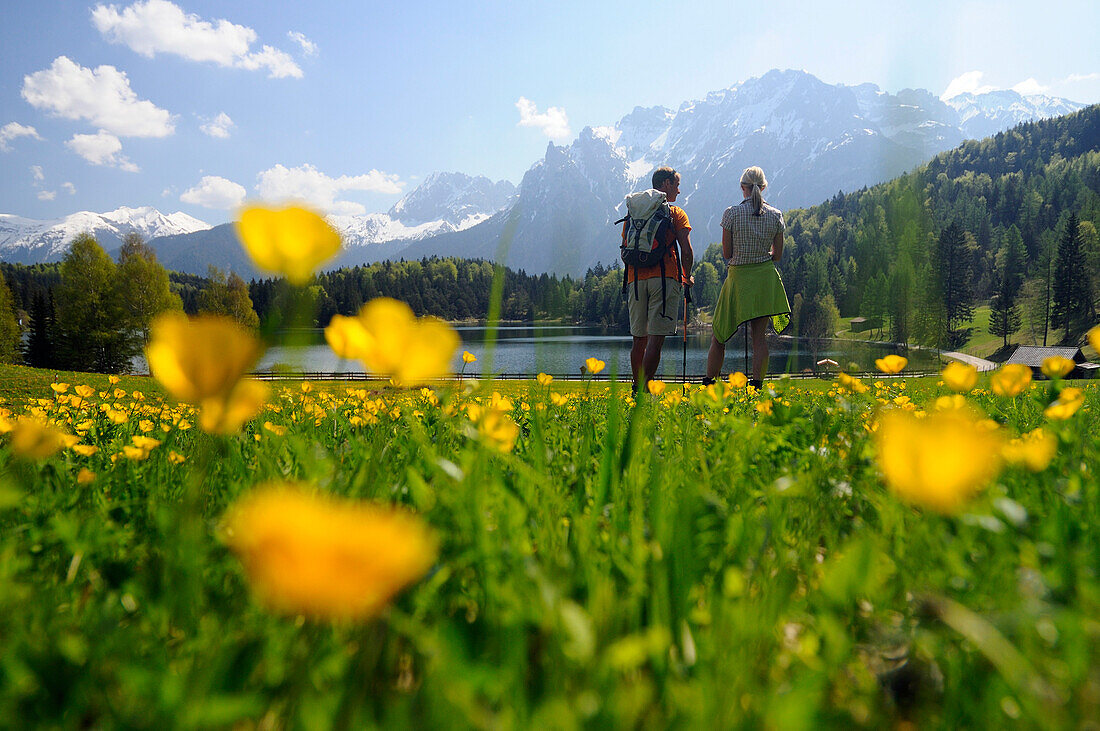 Couple hiking at Lautersee, Mittenwald, View towards Karwendel Mountain Range, Upper Bavaria, Bavaria, Germany, Europe