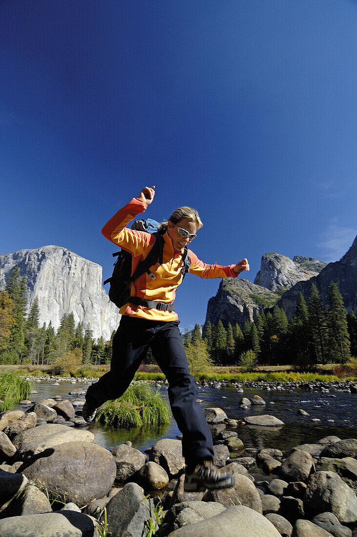 Frau mittleren Alters springt über Felsen, Yosemite-Nationalpark, Kalifornien, USA