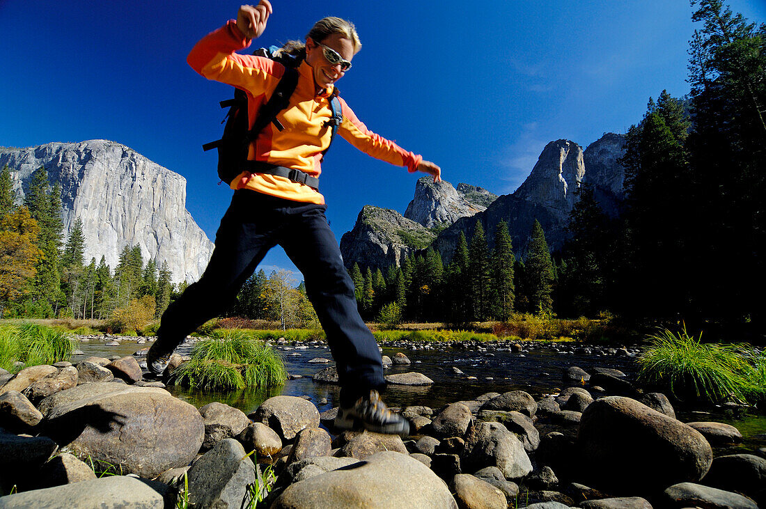 Frau mittleren Alters springt über Felsen, Yosemite-Nationalpark, Kalifornien, USA