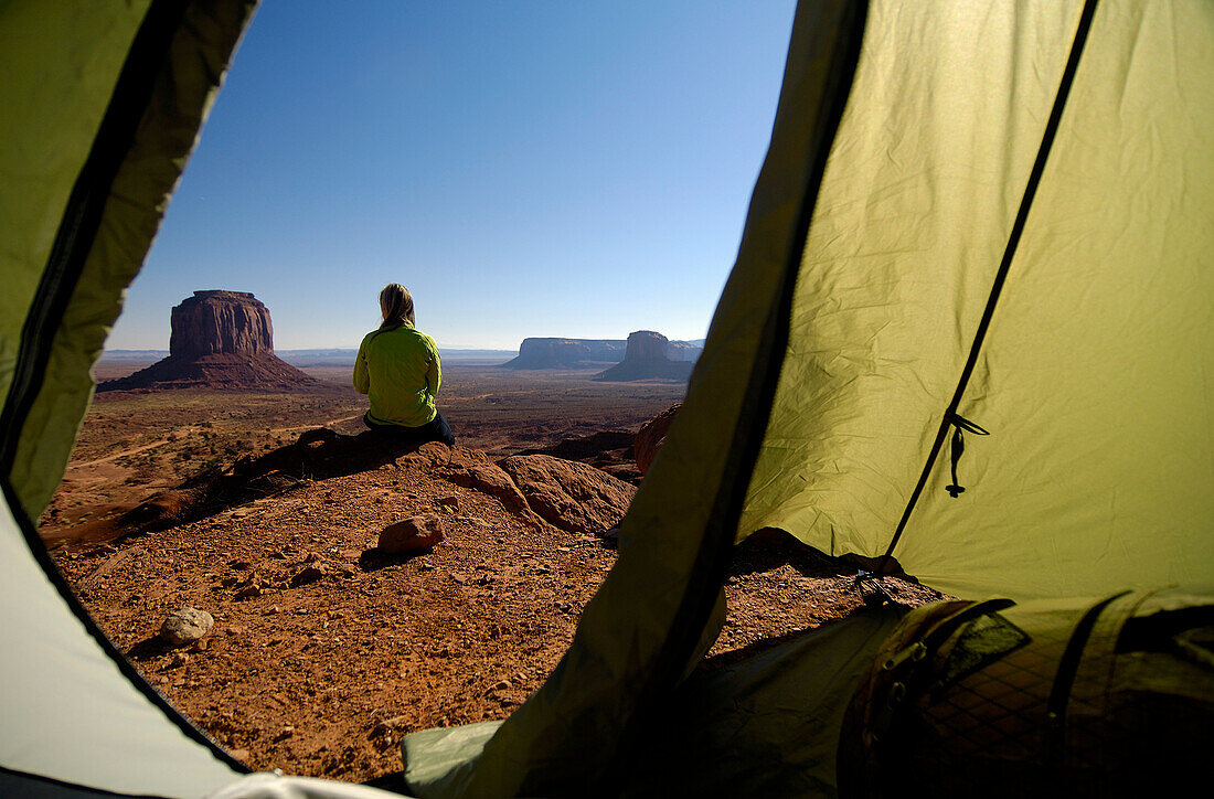 Blick aus einem Zelt auf eine sitzende Frau, Monument Valley, Utah, Nordamerika, Amerika