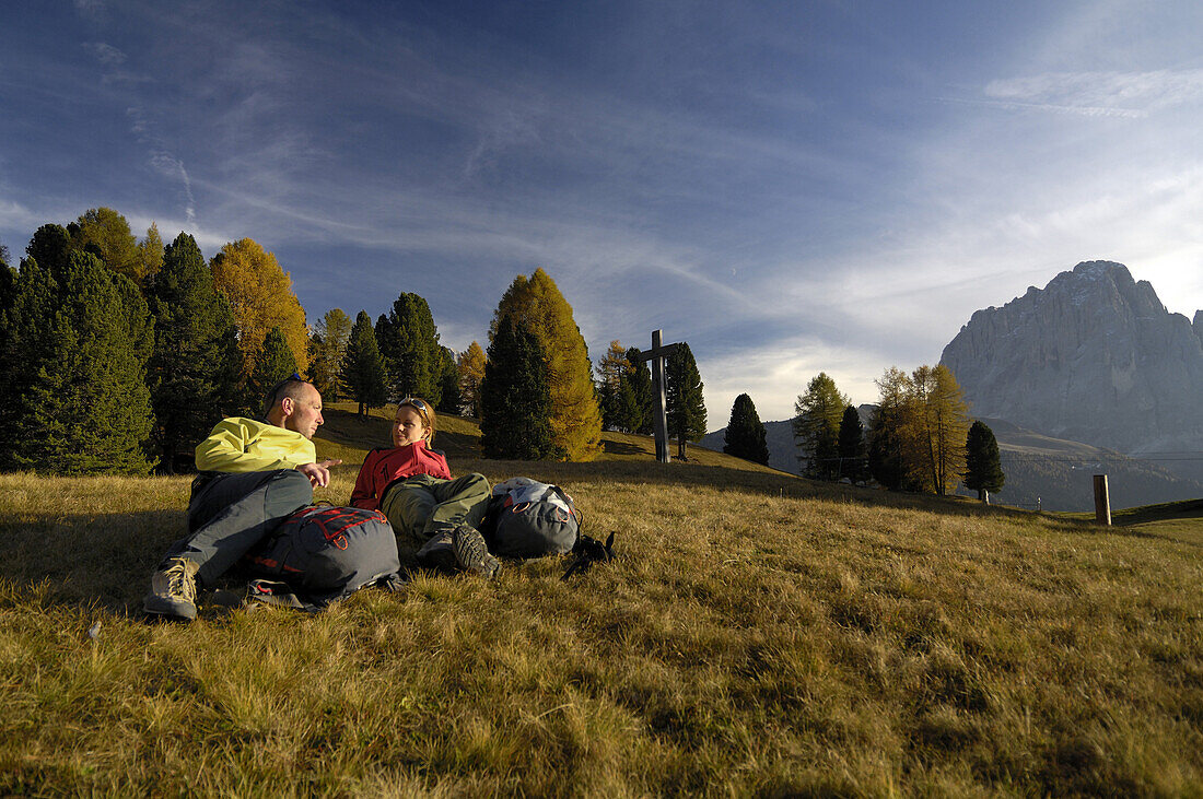 Mountain hikers resting on meadow, Dolomite Alps, Sëlva, Trentino-Alto Adige/Südtirol, Italy