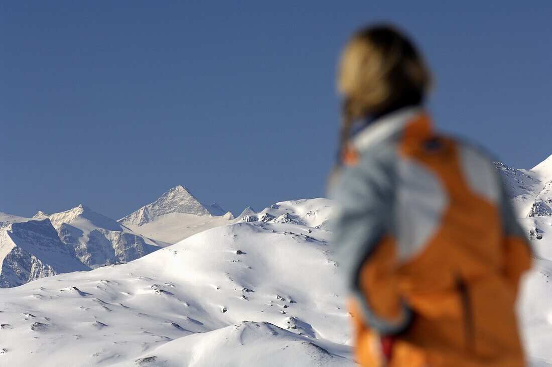 Frau betrachtet verschneite Bergkulisse, Fügen, Zillertal, Tirol, Österreich