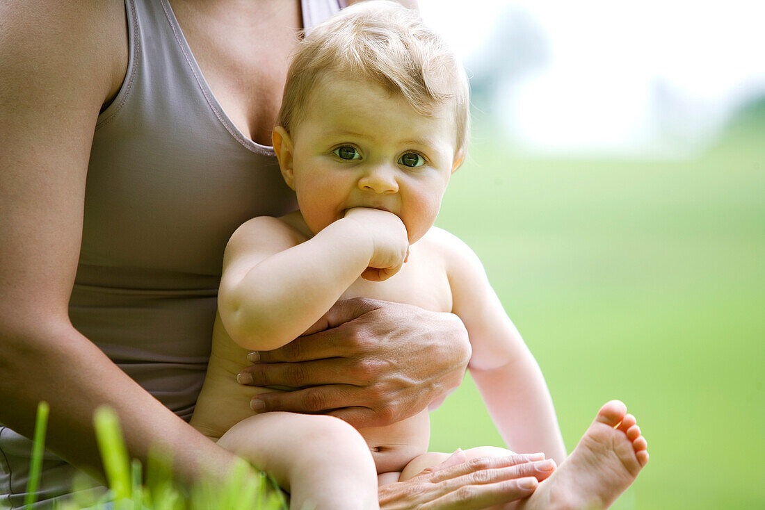 Mutter hält nacktes Baby, 9 Monate