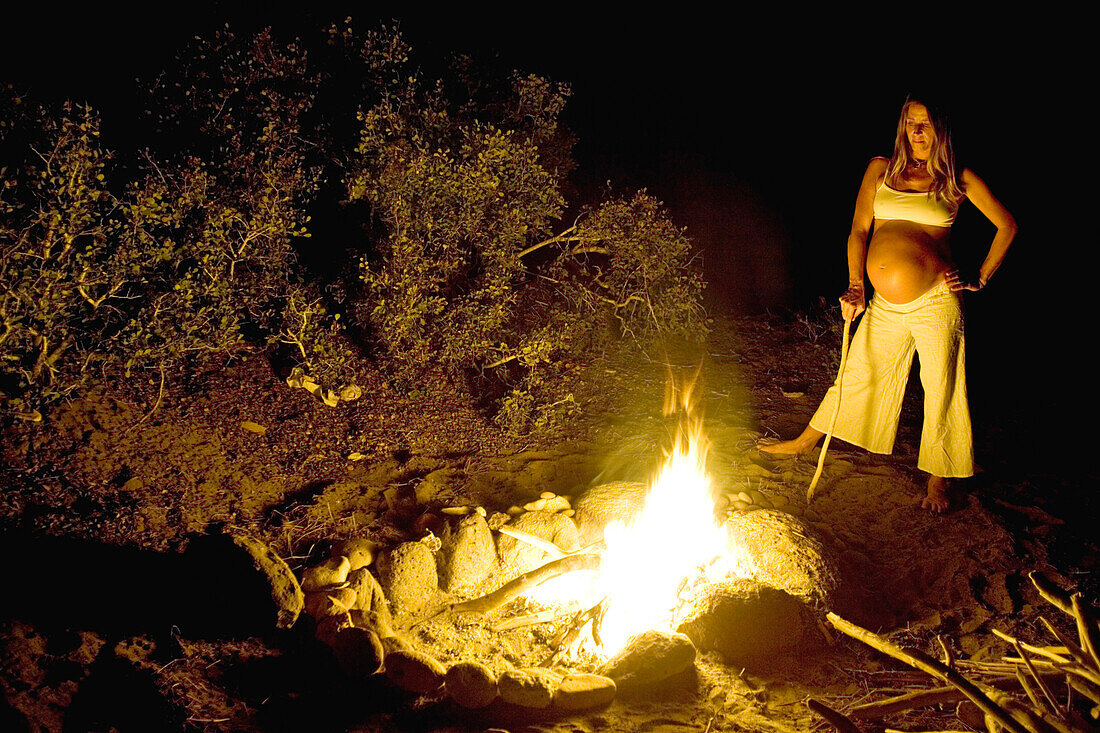Schwangere Frau steht am Lagerfeuer, Conejo, Baja California Süd, Mexiko