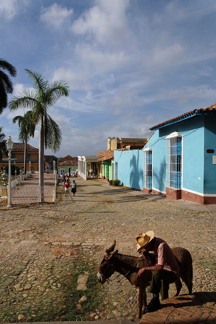 Senior man with donkey on Plaza Mayor, Trinidad, Sancti Spiritus, Cuba, West Indies