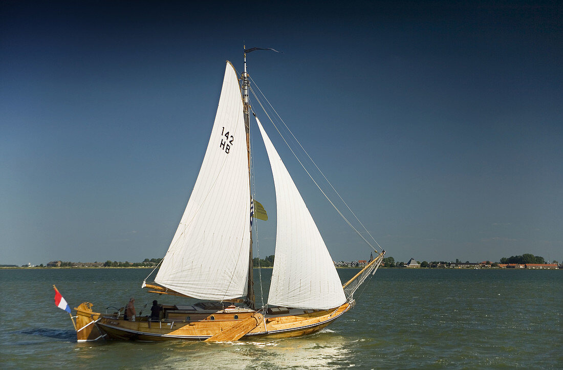 old sailing boat sailing in the coast  Volendam, Ijsselmeer lake, Holland, Netherlands, Europe