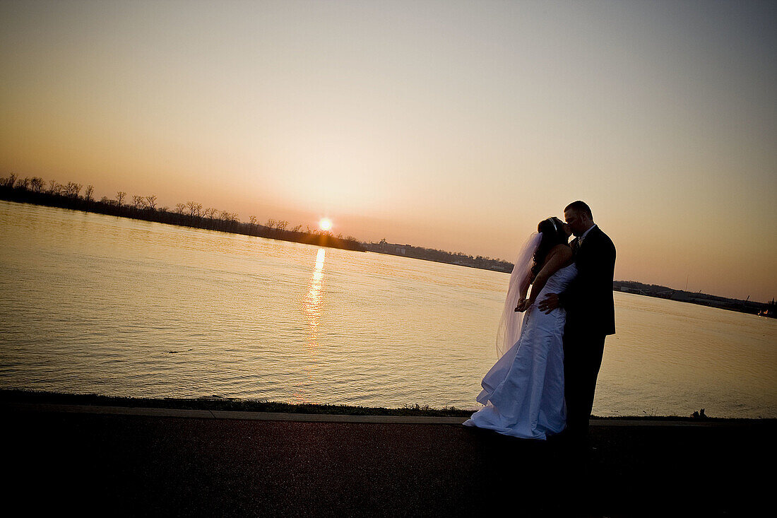 Wedding couple kissing, wide angle, Silhouette, downtown river front