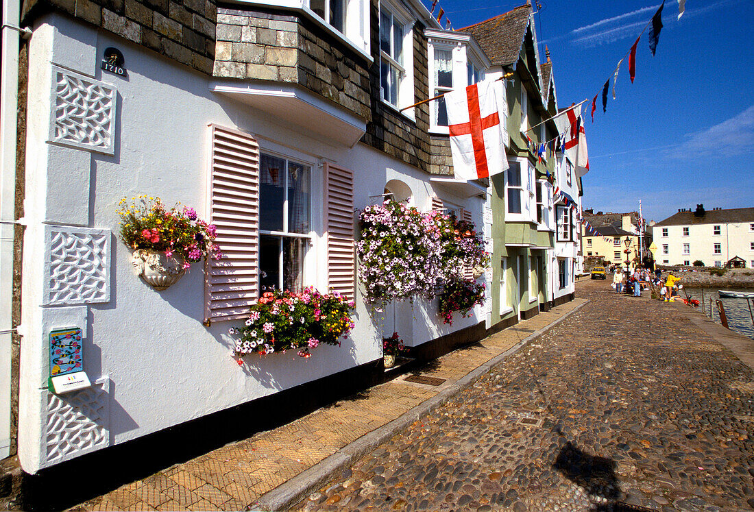 Street Scene with flags and flowers on harbourside buildings, Dartmouth, Devon, UK, England