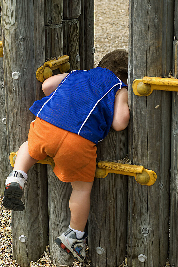 Backside, Blue, Boy, Child, Climbing, Color, Colour, Contemporary, Kid, Little, Orange, Playground, Playing, Vertical, V93-753252, agefotostock