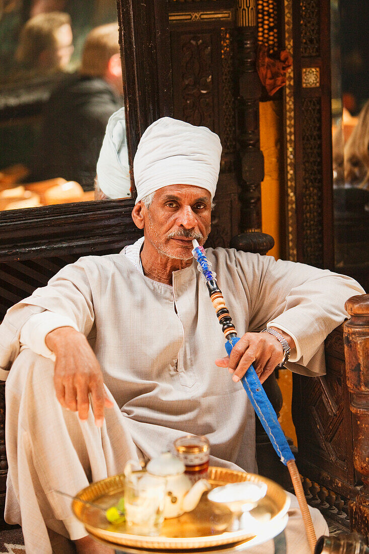 Älterer Mann raucht eine Wasserpfeife im Café Fishawi im Bazaar Khan el-Khalili, Kairo, Ägypten, Afrika