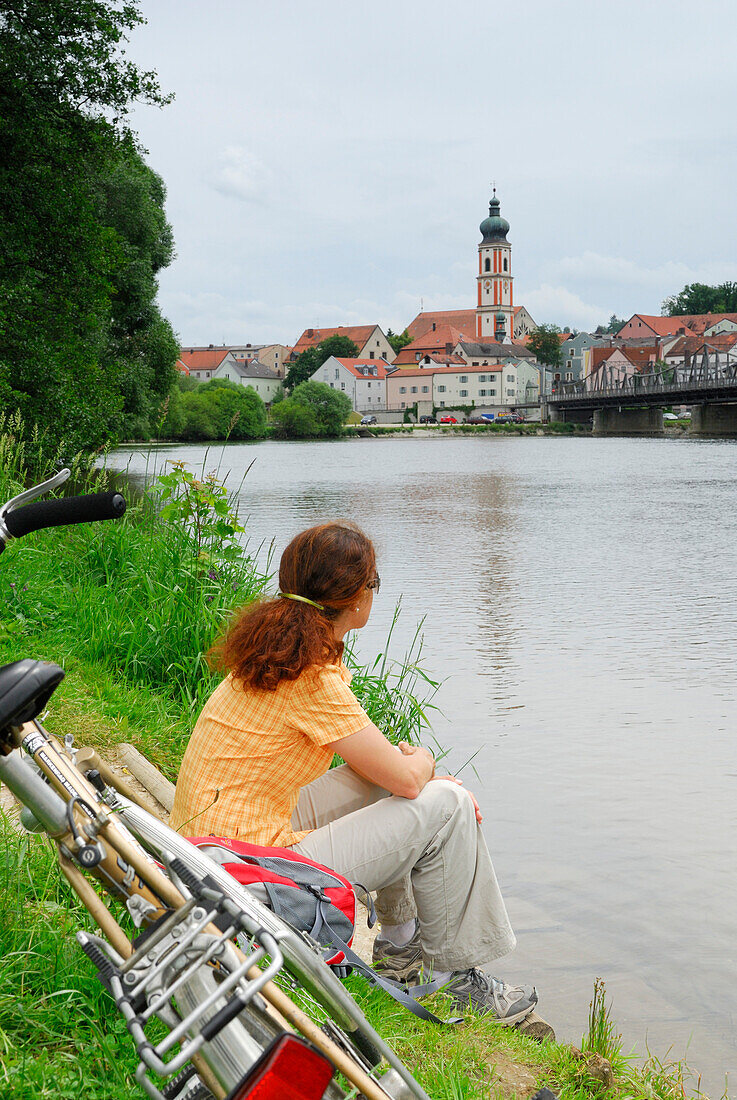 Woman sitting on Regen riverbank, Roding, Upper Palatinate, Bavaria, Germany