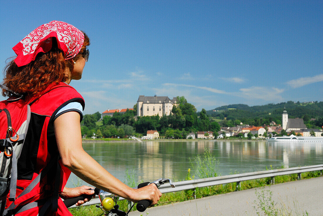 Woman looking over river Danube to Grein, Upper Austria, Austria