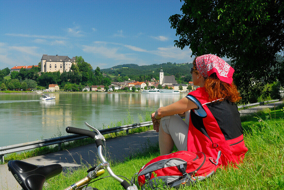 Frau blickt über die Donau auf Grein, Oberösterreich, Österreich