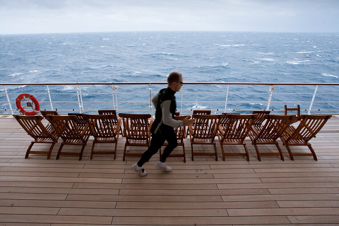 Passagier joggt, Jogger auf dem Promenadendeck, Kreuzfahrtschiff, Queen Mary 2, Nordatlantik, Atlantik
