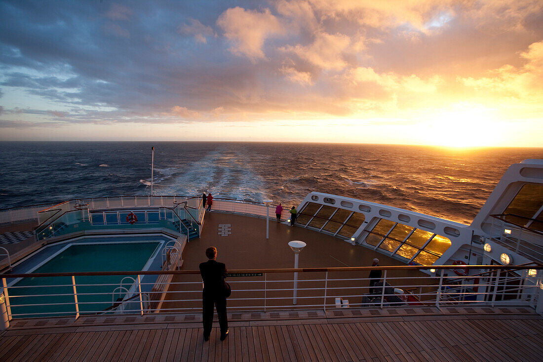 Passagiere schauen sich den Sonnenuntergang an, Passagiere auf dem Achterdeck, Kreuzfahrtschiff Queen Mary 2, Transatlantik, Nordatlantik, Atlantik