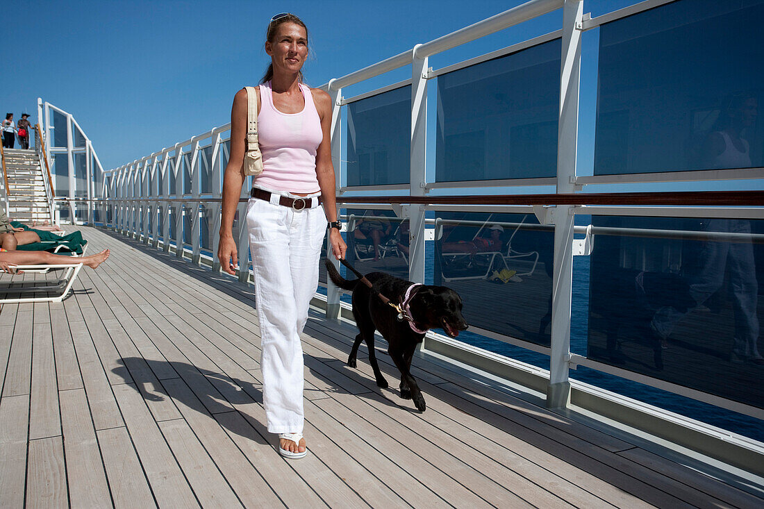 Cruise liner, Queen Mary 2, passenger taking her dog for a walk on the sun deck, Transatlantic