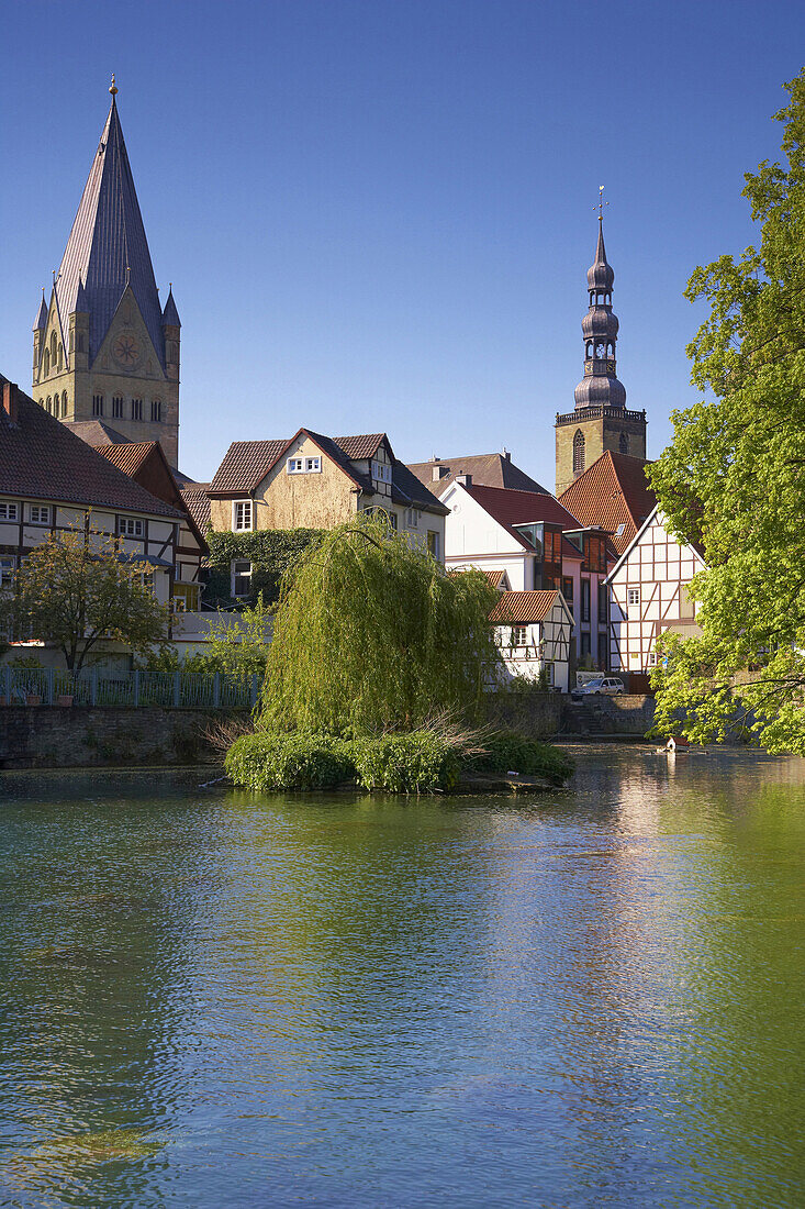 View over lake to St Peter's church and St Patrokli minster, Soest, North Rhine-Westphalia, Germany