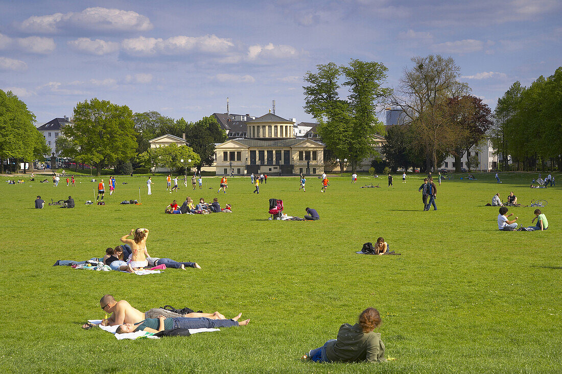 Leute sonnen sich auf einer Wiese im Hofgarten, Bonn, Nordrhein-Westfalen, Deutschland