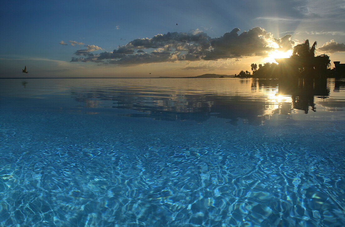 Blick über den Infinity Pool des Peacock Garden Resort bei Sonnenuntergang, Baclayon, Bohol, Philippinen, Asien